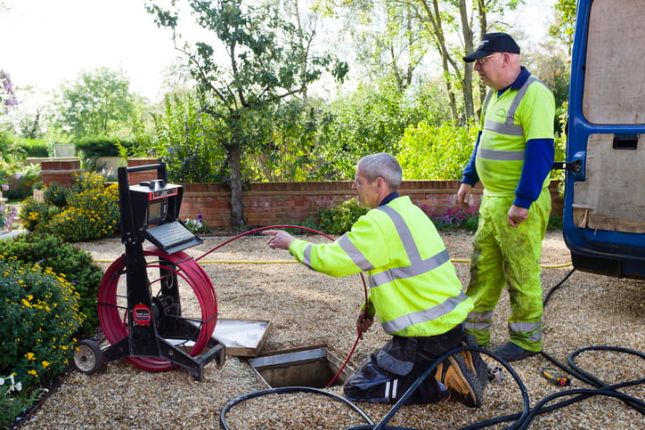 Plumbers sewer jetting outdoors in a garden