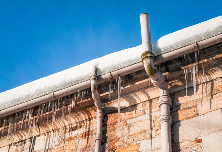 Frozen pipes and gutters. Snowy roof